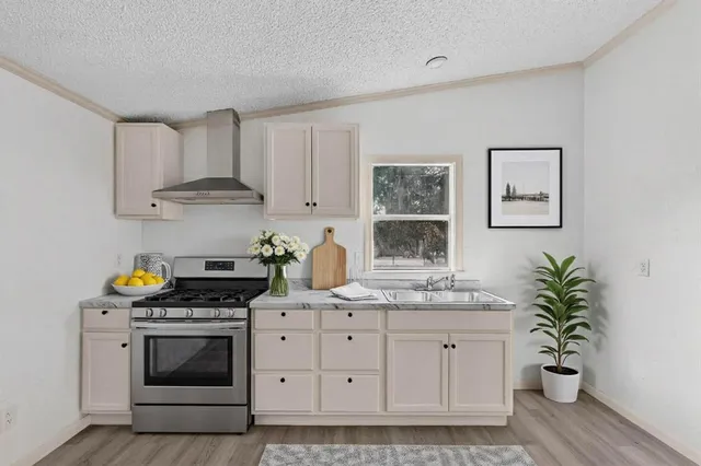 a kitchen with stainless steel appliances a white stove top oven and cabinets