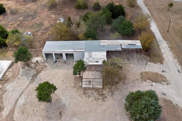 an aerial view of a house with a yard and greenery