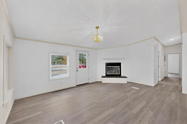 a view of an empty room with a window and a fireplace