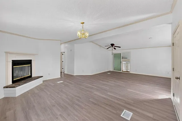 an empty room with windows and fireplace