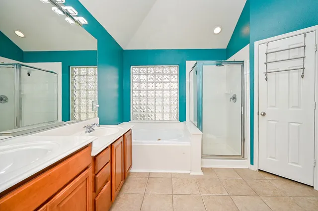 a spacious bathroom with a tub sink and mirror