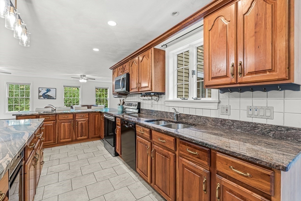 276 High Street Winchester, MA 01890 - Photo 12 of 38 a kitchen with stainless steel appliances granite countertop a sink and cabinets