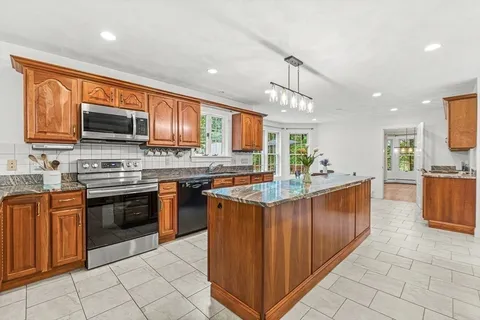 a kitchen with stainless steel appliances granite countertop a stove top oven a sink dishwasher and a microwave oven on the blue kitchen countertops