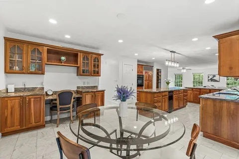 a living room with couches and kitchen view with wooden floor