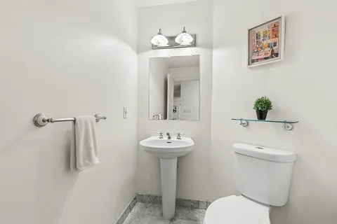 a bathroom with a toilet sink and mirror