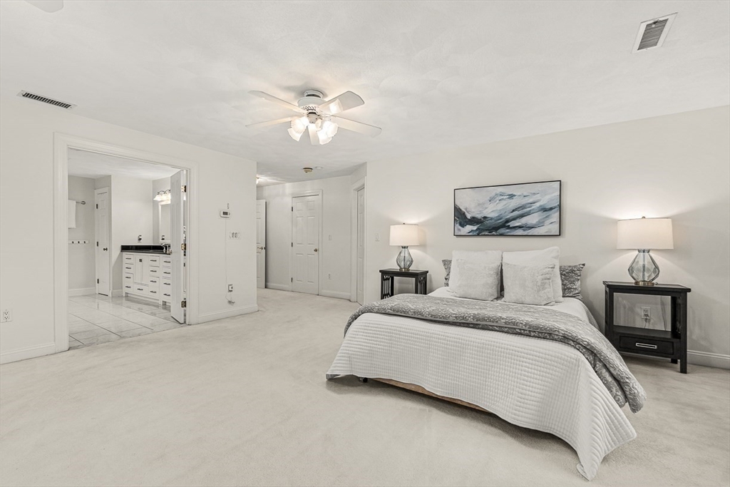 276 High Street Winchester, MA 01890 - Photo 22 of 38 a spacious bedroom with a bed and a chandelier