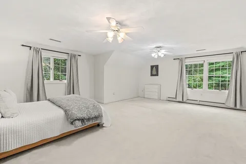 a spacious bedroom with a large bed and a chandelier