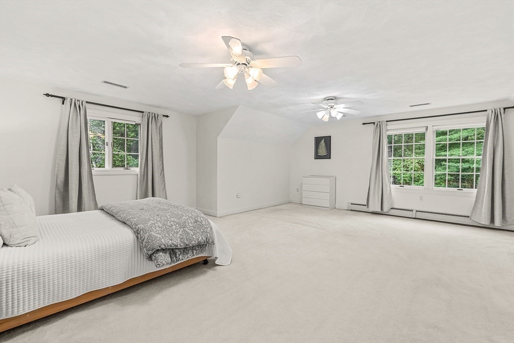 276 High Street Winchester, MA 01890 - Photo 23 of 38 a spacious bedroom with a large bed and a chandelier