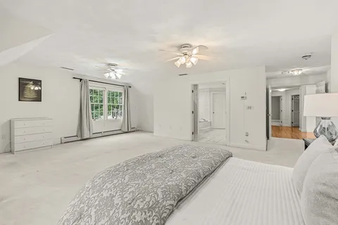 a spacious bedroom with a large bed and a chandelier