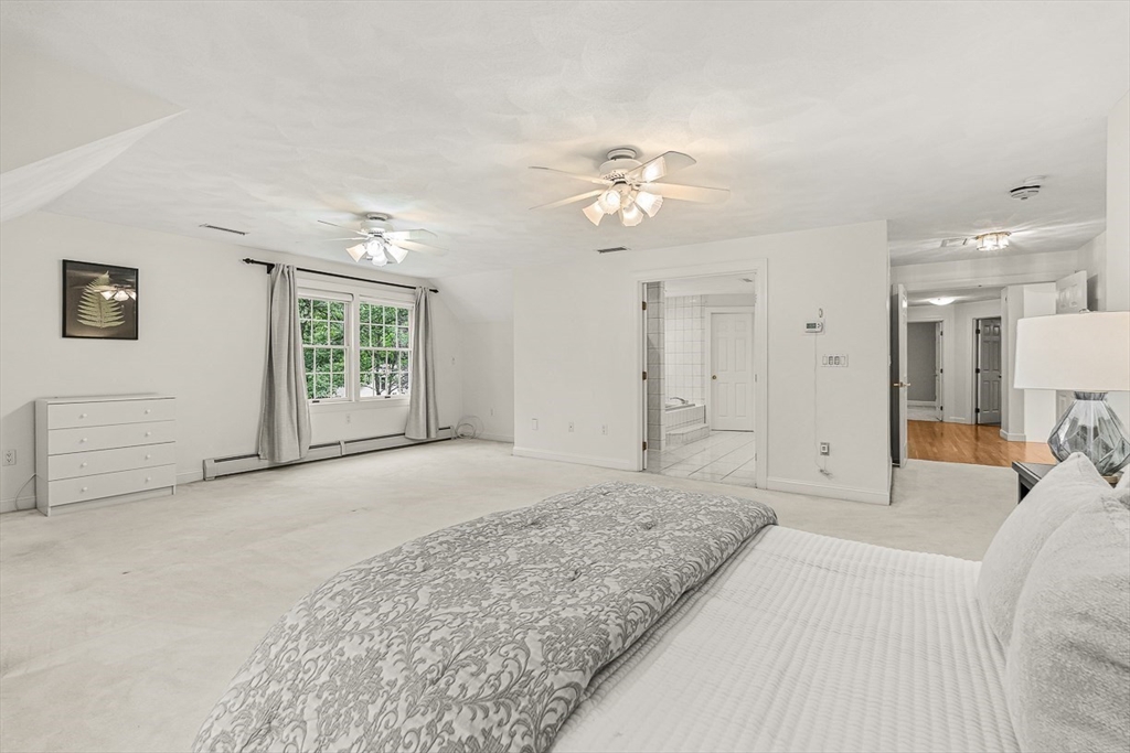 276 High Street Winchester, MA 01890 - Photo 24 of 38 a spacious bedroom with a large bed and a chandelier
