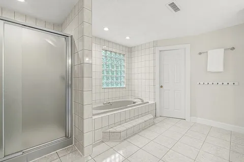 a spacious bathroom with a bathtub and a shower
