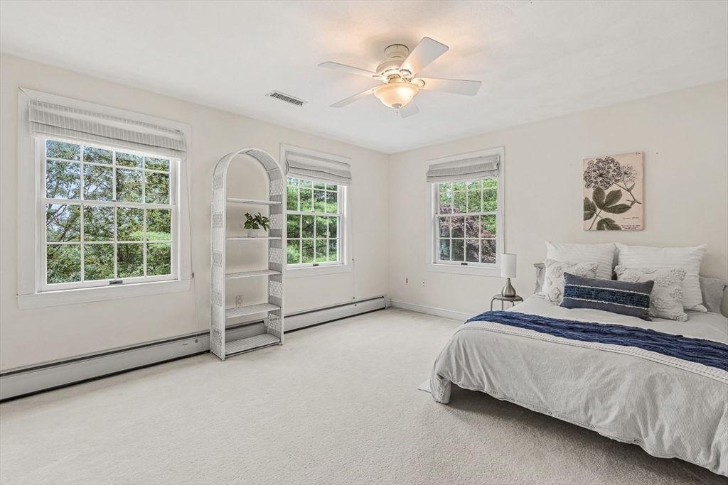 276 High Street Winchester, MA 01890 - Photo 28 of 38 a spacious bedroom with a bed a window and potted plant on the dresser
