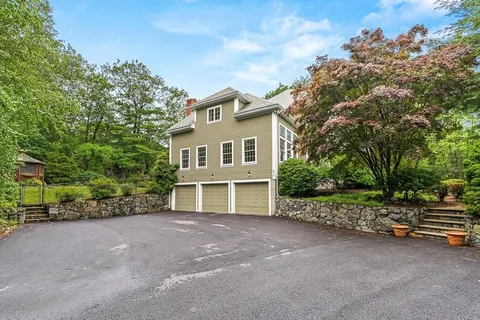 a view of a house with a backyard and bushes