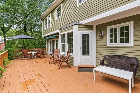 a view of a patio with table and chairs under an umbrella with wooden floor