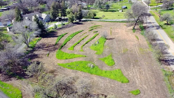 an aerial view of a house with a yard and lake