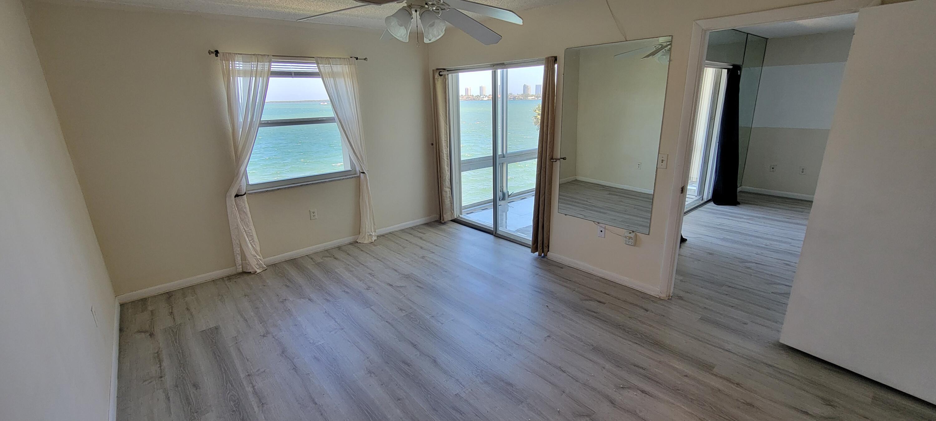410 Wilma Circle, Unit 308 Riviera Beach, FL 33404 - Photo 21 of 27 an empty room with wooden floor and a window