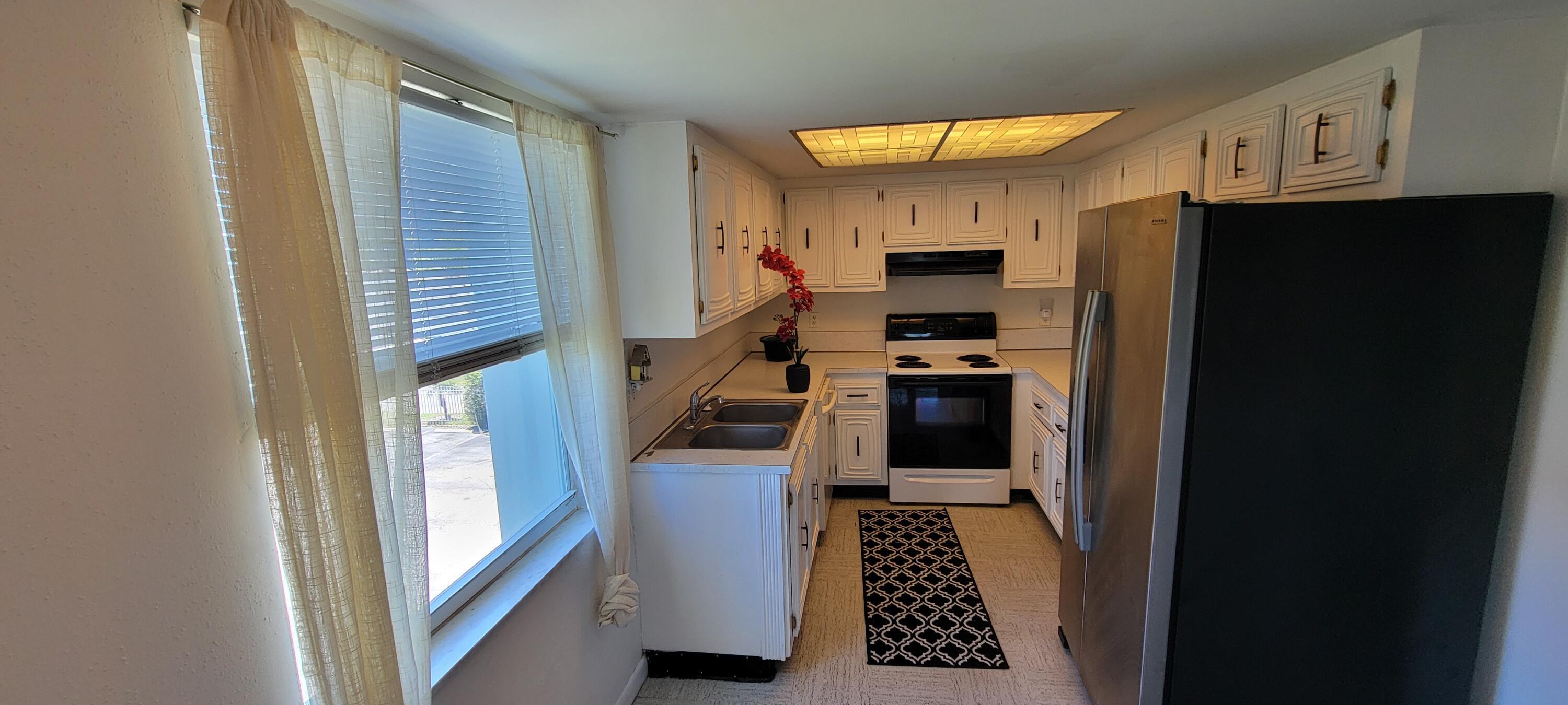 410 Wilma Circle, Unit 308 Riviera Beach, FL 33404 - Photo 27 of 27 a kitchen with stainless steel appliances granite countertop a refrigerator and a stove