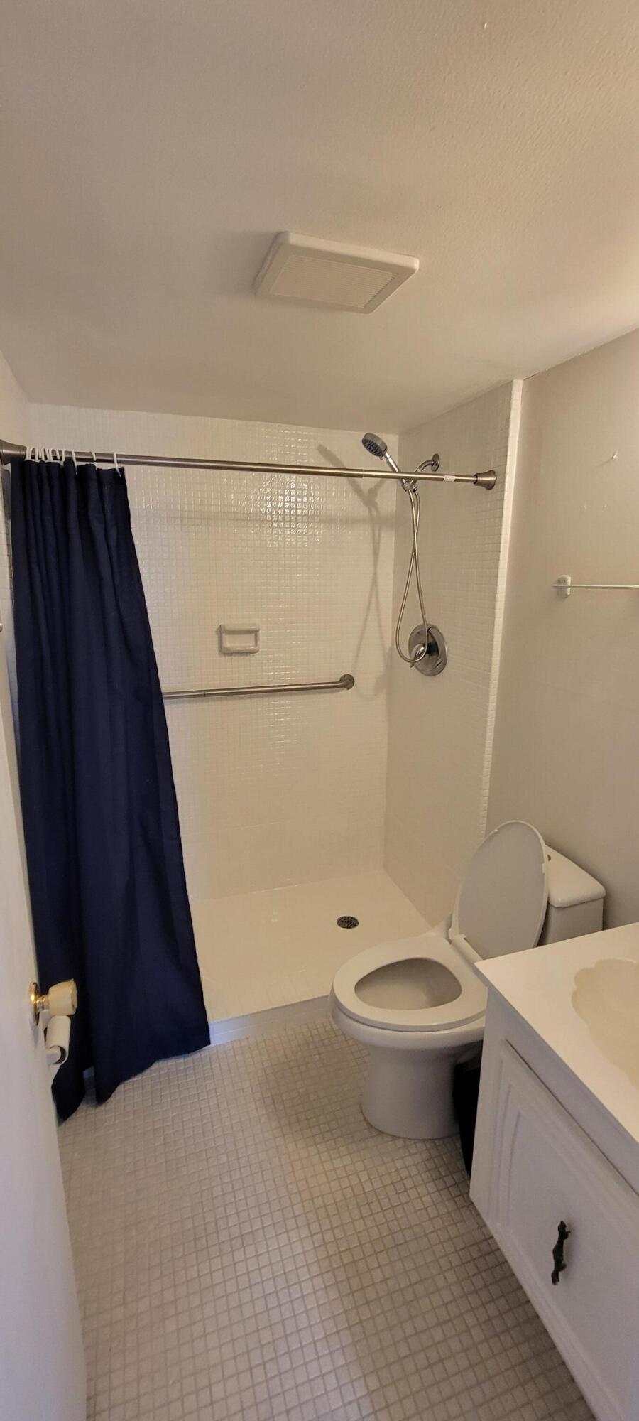 410 Wilma Circle, Unit 308 Riviera Beach, FL 33404 - Photo 8 of 27 a bathroom with a granite countertop sink toilet and shower