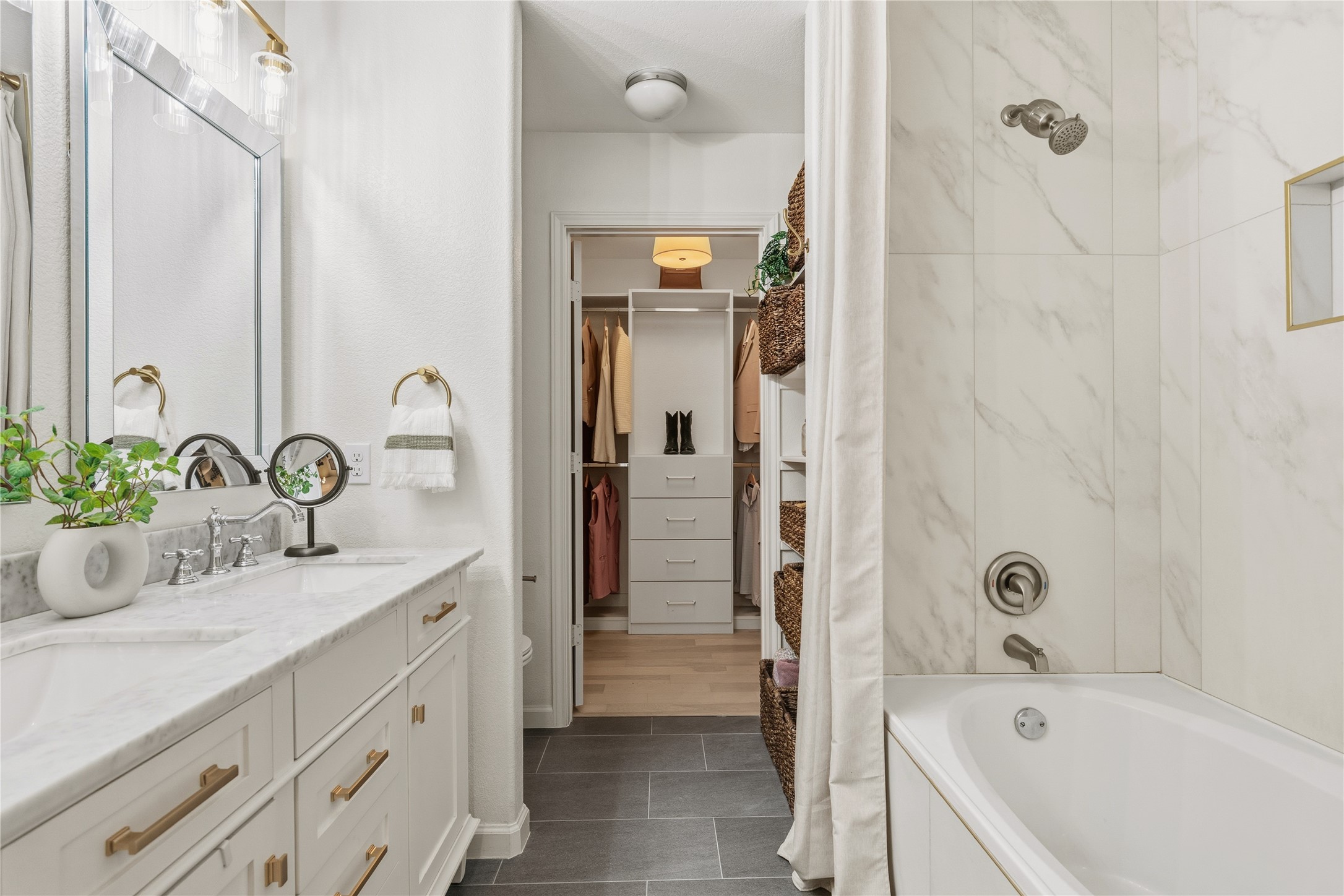 7400 South Glenn Street Austin, TX 78744 - Photo 15 of 36 Bathroom with double vanity, shower / bathtub combination with curtain, and a walk in closet