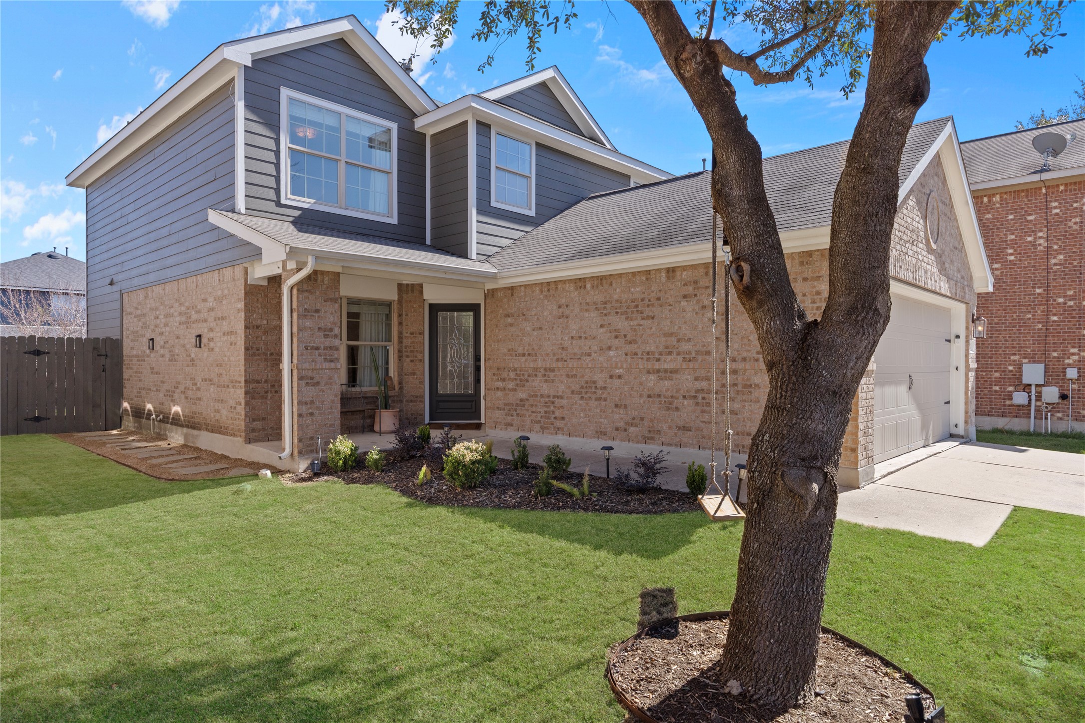 7400 South Glenn Street Austin, TX 78744 - Photo 2 of 36 View of front of house featuring brick siding, a garage, driveway, roof with shingles, and a patio