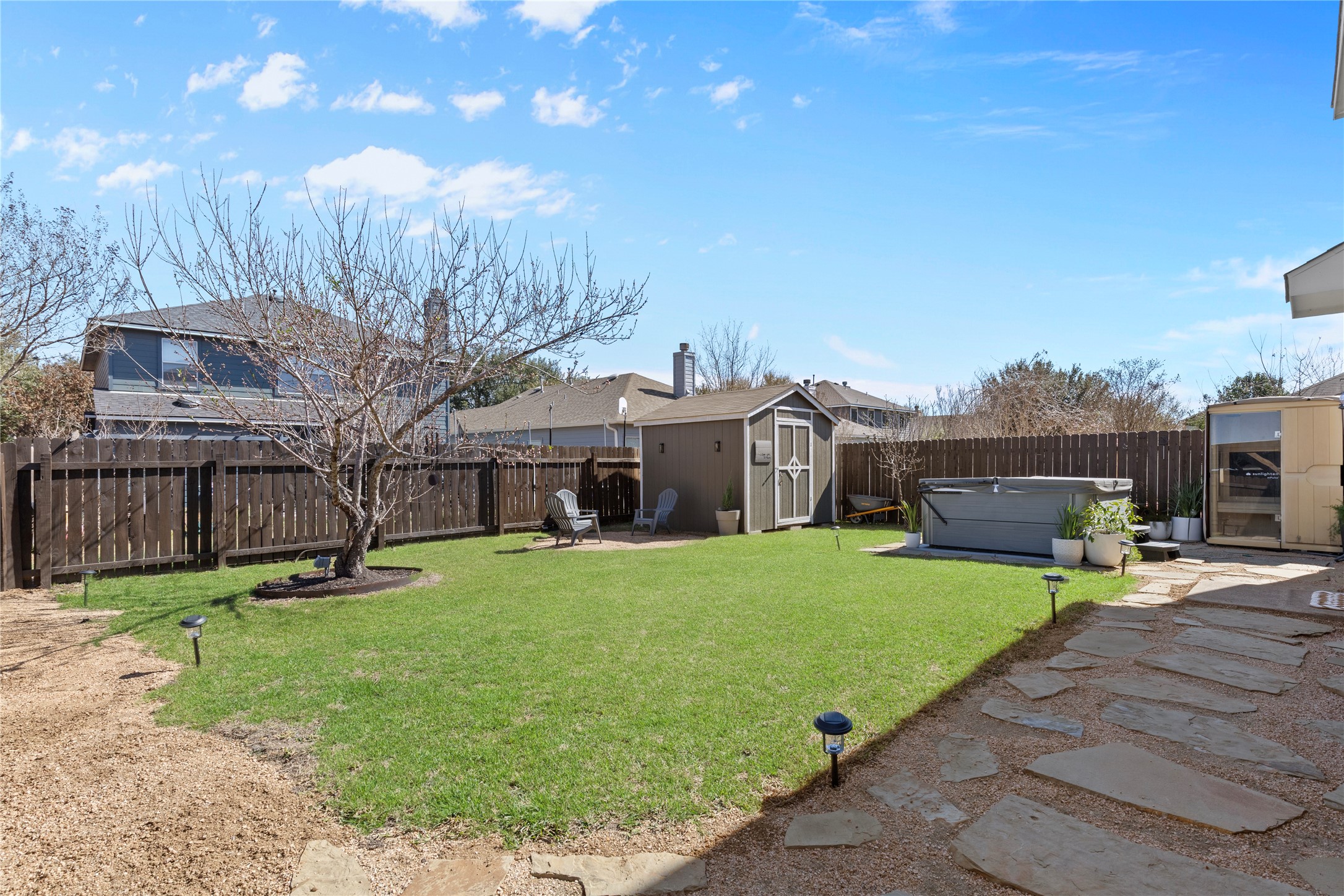 7400 South Glenn Street Austin, TX 78744 - Photo 28 of 36 Fenced backyard featuring a storage shed, a hot tub, and a patio area