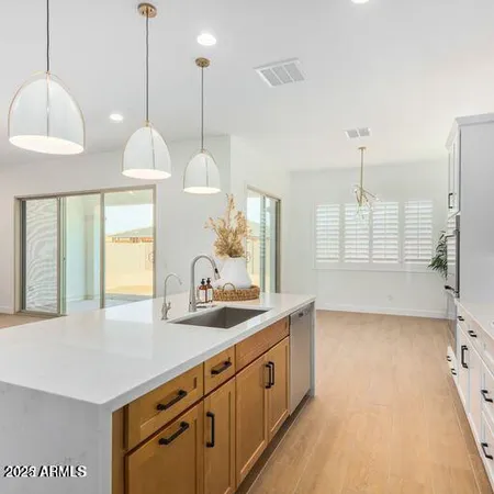 a kitchen with granite countertop a sink a window and chairs