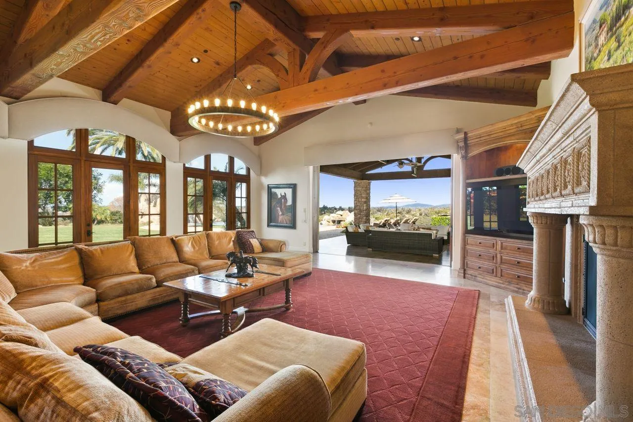 6658 Niemann Ranch Road Rancho Santa Fe, CA 92067 - Photo 13 of 35 a living room with furniture a chandelier and a flat screen tv