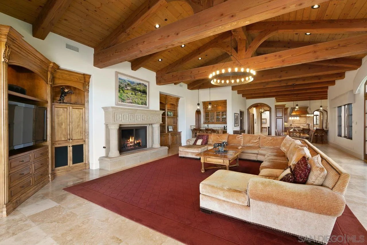6658 Niemann Ranch Road Rancho Santa Fe, CA 92067 - Photo 14 of 35 a living room with furniture a fireplace and a chandelier