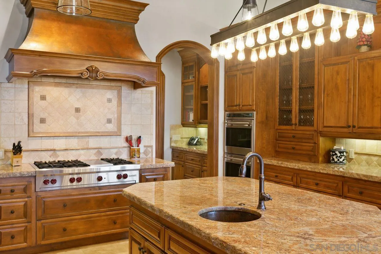 6658 Niemann Ranch Road Rancho Santa Fe, CA 92067 - Photo 18 of 35 a kitchen with stainless steel appliances granite countertop a sink and a stove