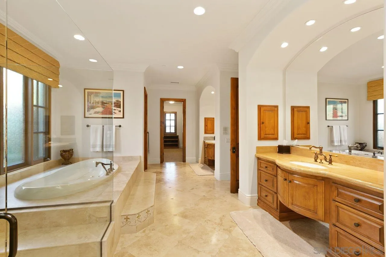 6658 Niemann Ranch Road Rancho Santa Fe, CA 92067 - Photo 24 of 35 a large bathroom with double vanity sinks a large mirror and a shower