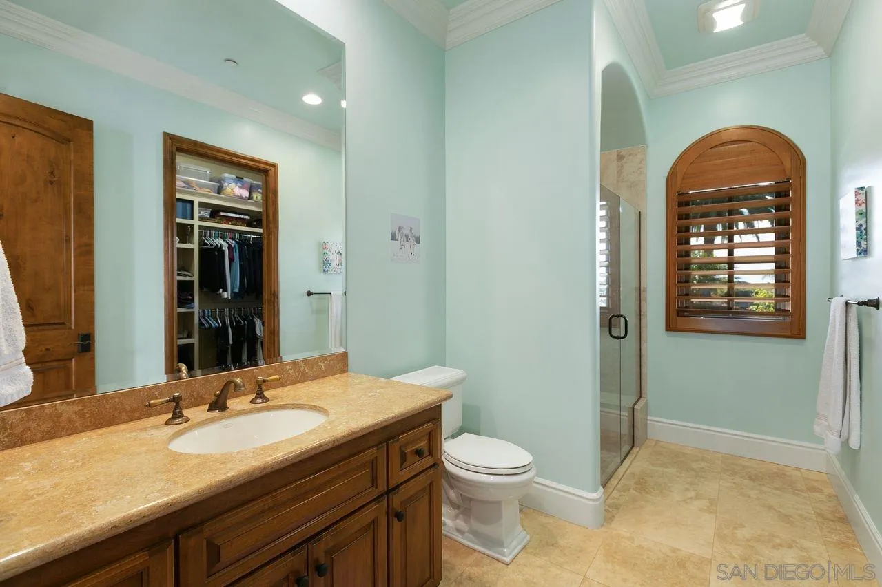 6658 Niemann Ranch Road Rancho Santa Fe, CA 92067 - Photo 26 of 35 a bathroom with a granite countertop toilet sink and mirror