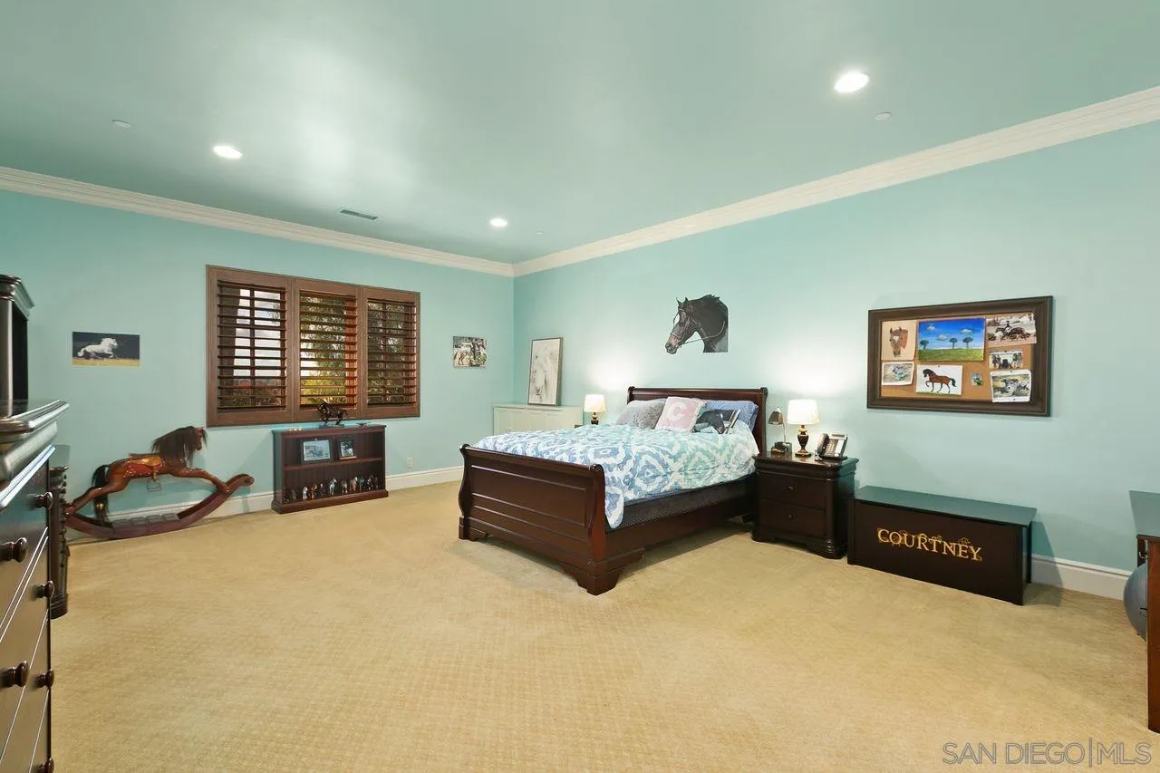 6658 Niemann Ranch Road Rancho Santa Fe, CA 92067 - Photo 27 of 35 a spacious bedroom with a bed and a couch