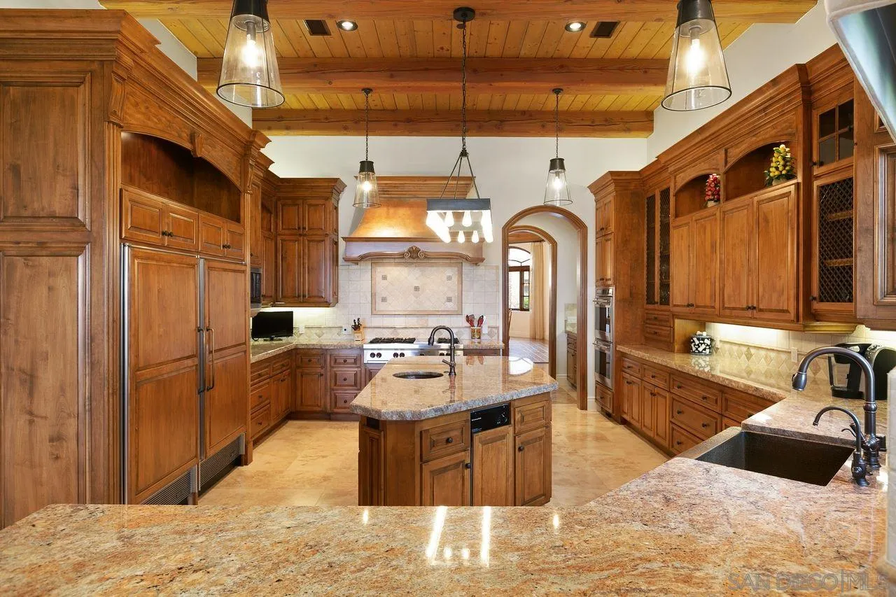 6658 Niemann Ranch Road Rancho Santa Fe, CA 92067 - Photo 4 of 35 a large kitchen with stainless steel appliances kitchen island granite countertop a sink and cabinets