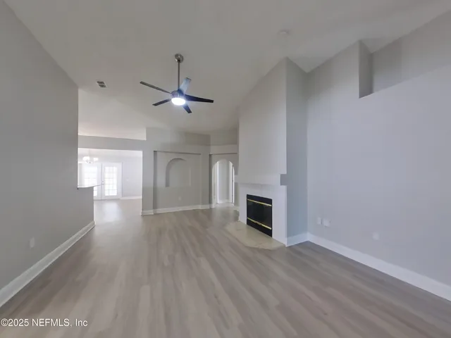a view of empty room with wooden floor and window