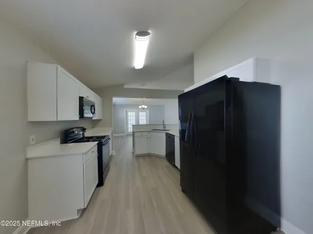 a kitchen with a refrigerator and a stove top oven