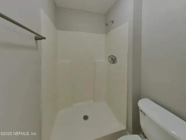 a bathroom with a shower a toilet and a sink