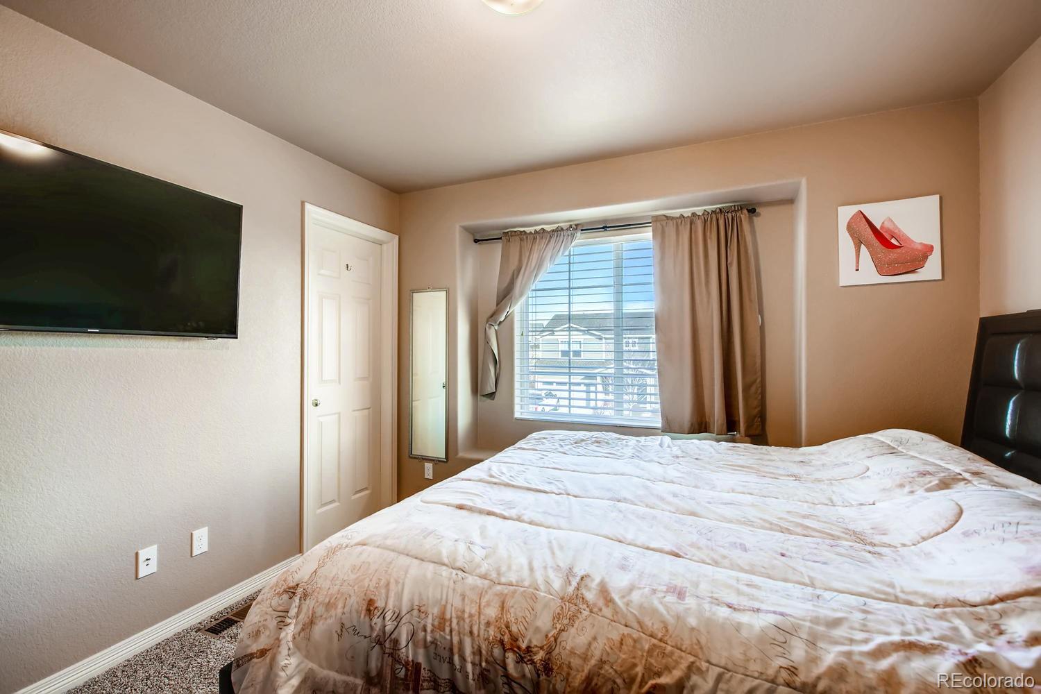 2184 Reed Grass Way Colorado Springs, CO 80915 - Photo 24 of 29 a bedroom with a bed and a flat screen tv