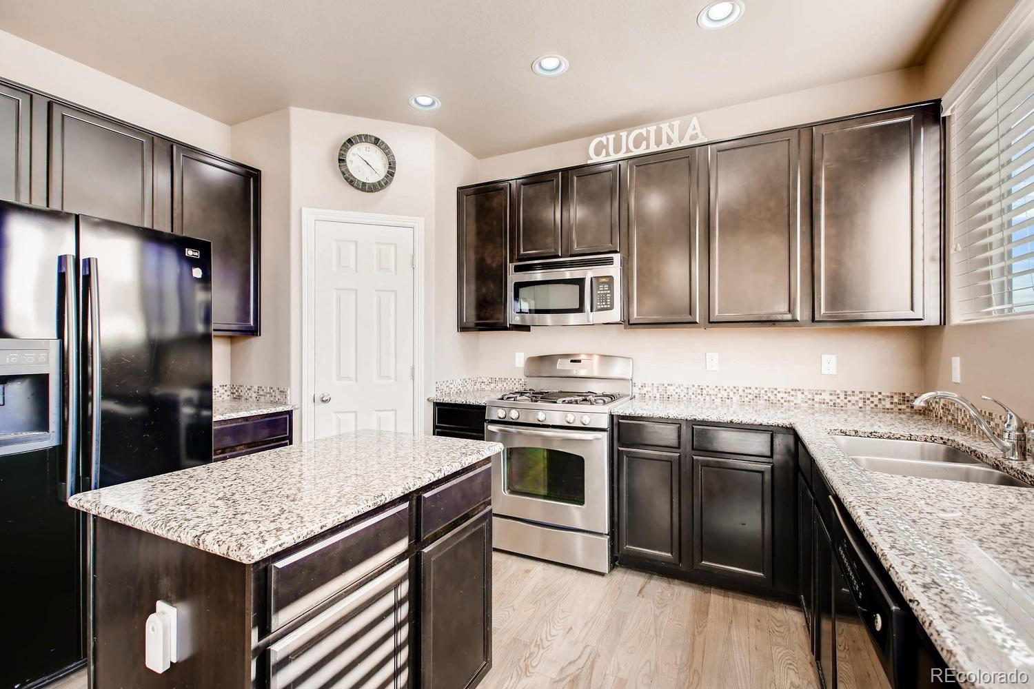 2184 Reed Grass Way Colorado Springs, CO 80915 - Photo 5 of 29 a kitchen with stainless steel appliances granite countertop a sink stove and refrigerator