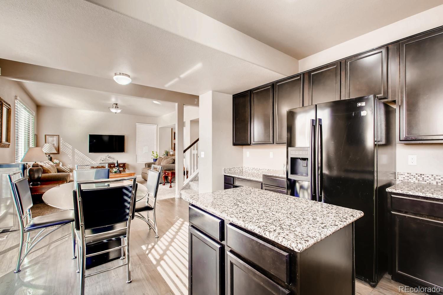 2184 Reed Grass Way Colorado Springs, CO 80915 - Photo 6 of 29 a kitchen with kitchen island a counter space stainless steel appliances and cabinets