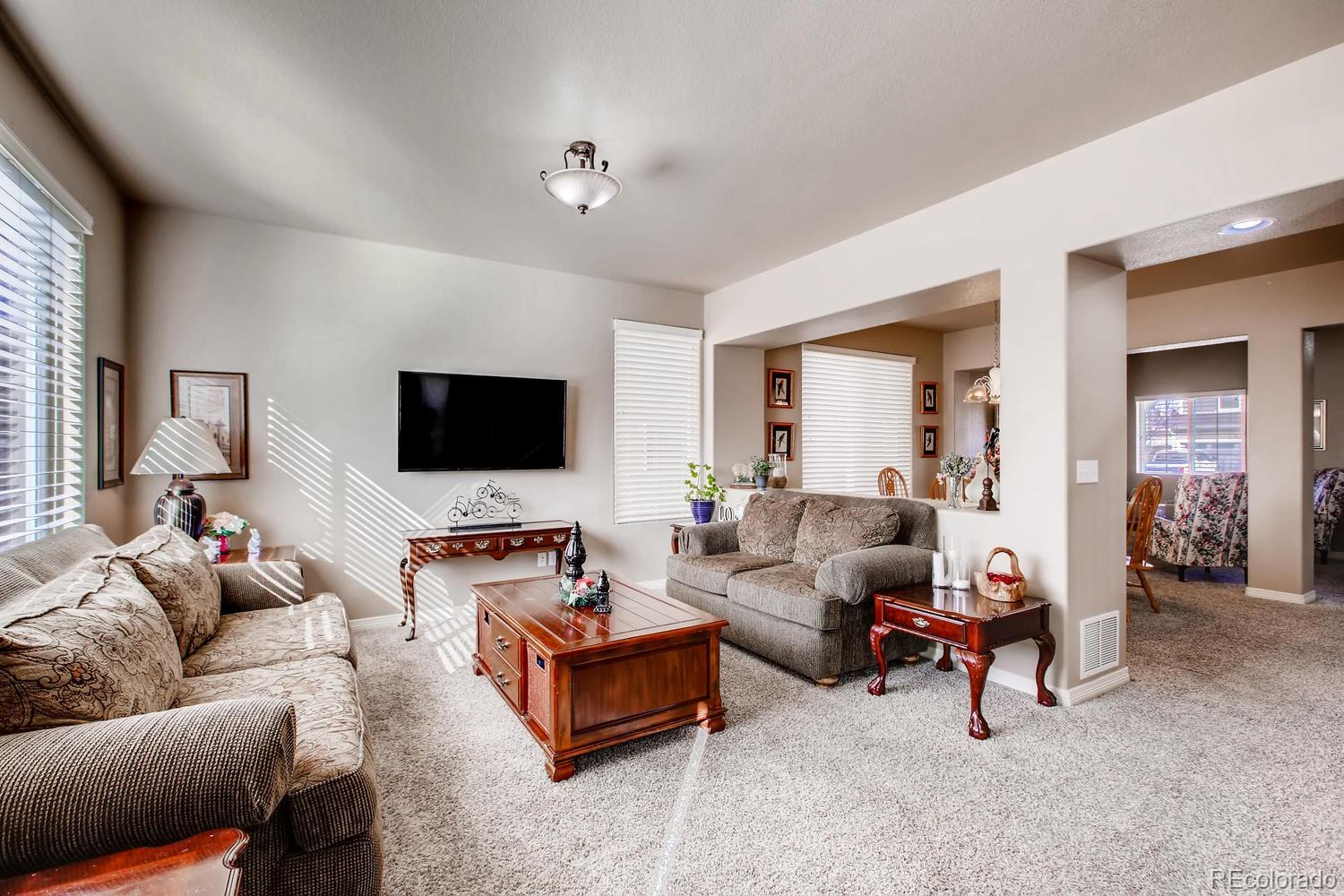 2184 Reed Grass Way Colorado Springs, CO 80915 - Photo 9 of 29 a living room with furniture and a flat screen tv