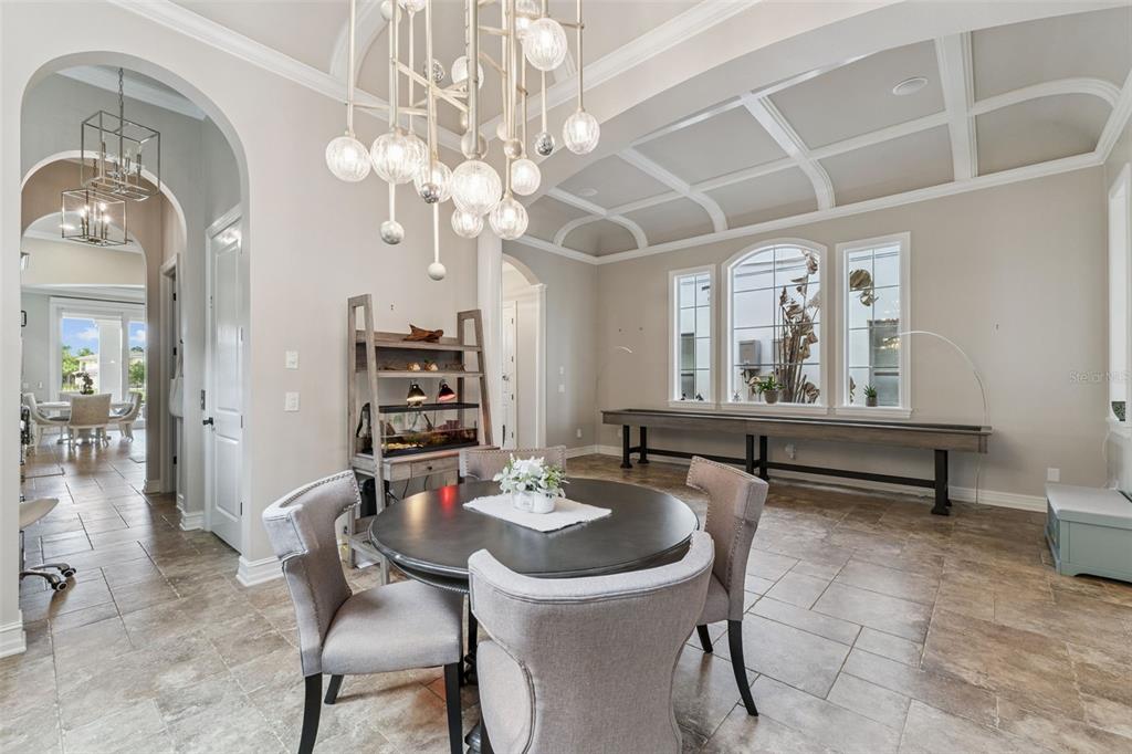 1172 Castle Pines Court Reunion, FL 34747 - Photo 22 of 65 a dining room with wooden floor a chandelier a wooden table and chairs