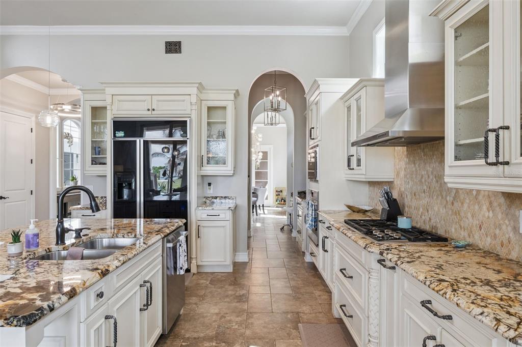 1172 Castle Pines Court Reunion, FL 34747 - Photo 26 of 65 a large kitchen with stainless steel appliances granite countertop a lot of counter space and a sink