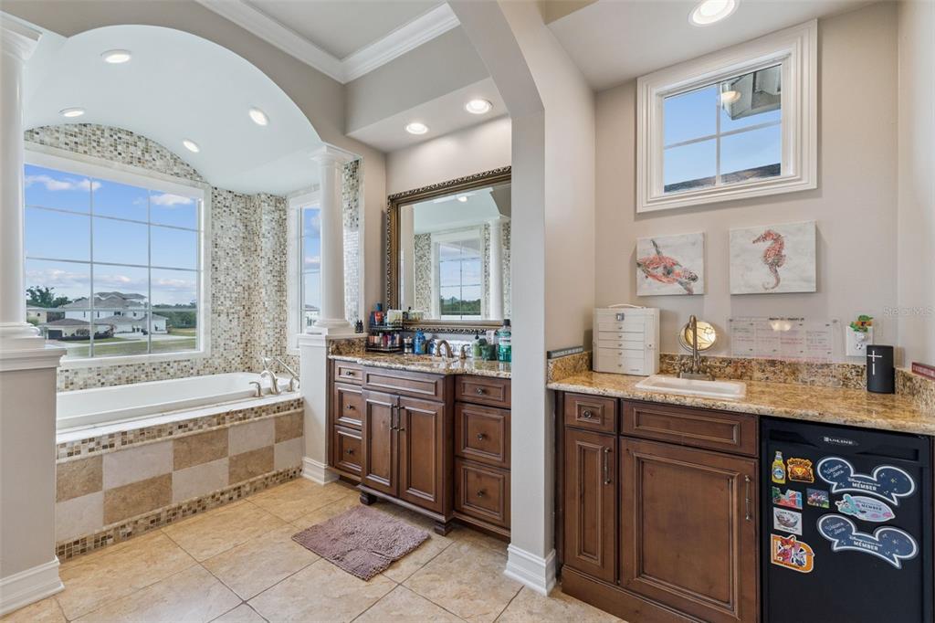 1172 Castle Pines Court Reunion, FL 34747 - Photo 33 of 65 a spacious bathroom with a granite countertop double vanity sink a mirror and a bathtub