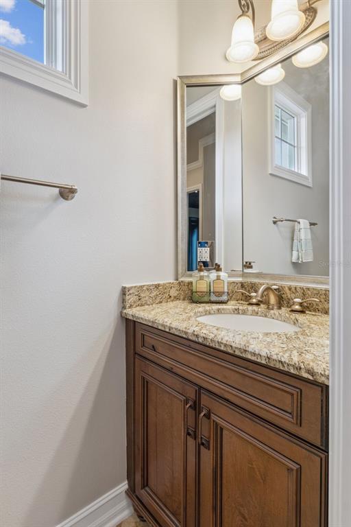 1172 Castle Pines Court Reunion, FL 34747 - Photo 35 of 65 a bathroom with a granite countertop sink and a mirror