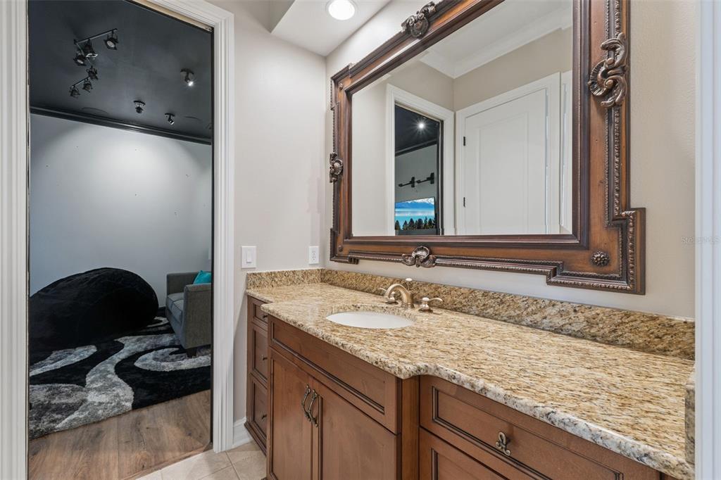 1172 Castle Pines Court Reunion, FL 34747 - Photo 37 of 65 a bathroom with a granite countertop sink and a mirror