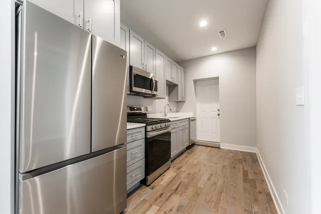 a kitchen with stainless steel appliances a refrigerator sink and microwave