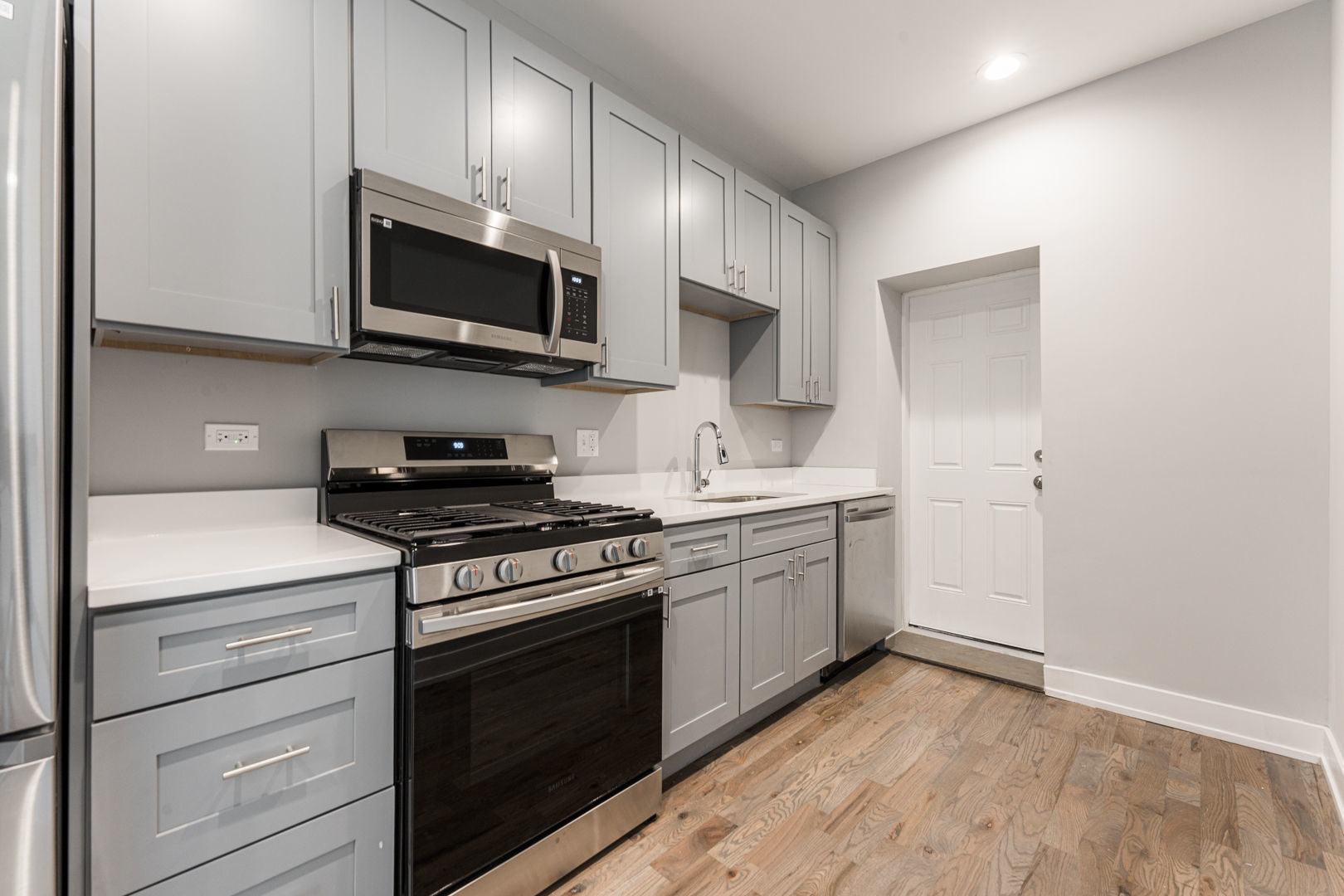 926 West 32nd Place, Unit 2F Chicago, IL 60608 - Photo 4 of 18 a kitchen with stainless steel appliances white cabinets and stove top oven