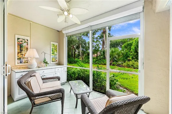 a living room with a floor to ceiling window furniture and a porch