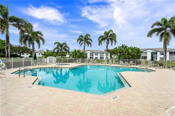 a view of swimming pool with palm trees