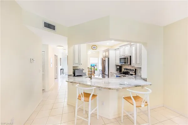 a large white kitchen with granite countertop a sink and cabinets